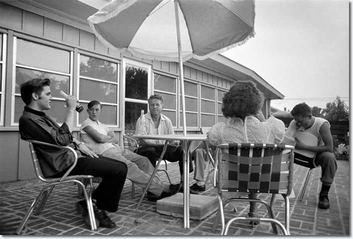 Taking a break from fans, Elvis relaxed with family on the patio of his home at 1034 Audubon Drive in Memphis. Elvis paid $40,000 for the four-bedroom, ranch-style house in 1956, a year before he puchased Graceland. On the same day this photograph was taken, July 4, Elvis also played a benefit concert at Russwood Park.