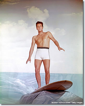 April 1961: This picture totally illustrates his unfortunate movie career. I especially love the fake rock that's holding the surfboard. The whole thing exemplifies his Hollywood years. This was a Paramount [Studios] giveaway -- they sent out 8x10 color positives to the newspapers, which is very unusual.