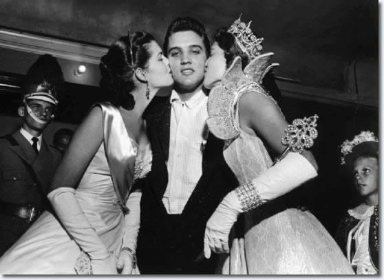 Maid of Cotton Patricia Cowden (left) and Memphis Cotton Carnival Queen Clare Mallory gave Elvis Presley royal kisses just before the rock and roll singer walked on stage before a packed Ellis Auditorium audience on the night of May 15, 1956