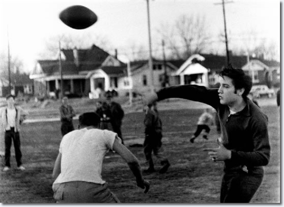Elvis Presley fades back and heaves a pass during a sandlot touch football game. It connected for one of the many touchdowns.