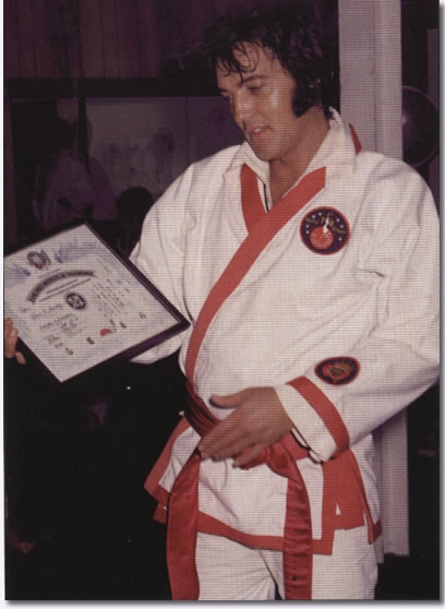 Elvis Presley with certificate for his honorary 8th degree black belt from Kang Rhee