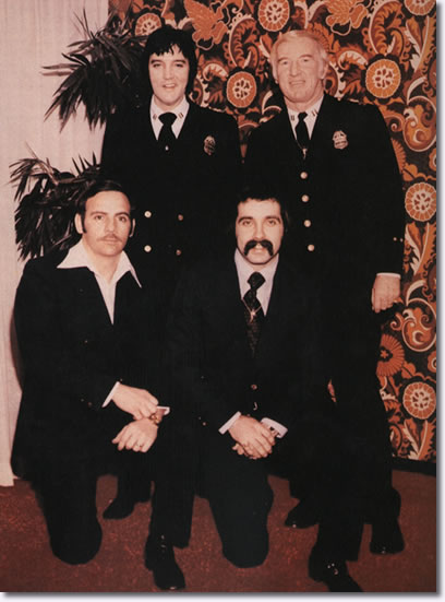 Elvis in Denver Police uniform with (standing right) Denver Police Captain Jerry Kennedy and (kneeling, left to right) officers Bob Cantwell and Ron Pietrafeso, January 1976.