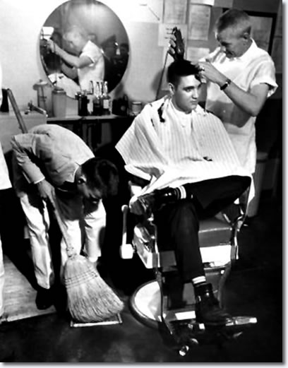 Elvis Presley receiving a haircut from a US Army barber, Fort Chaffee, Arkansas.